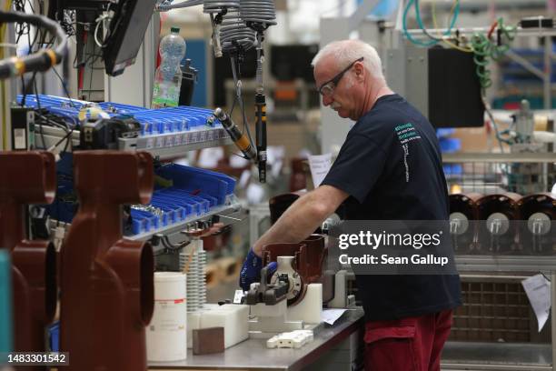 Worker assembles components at a Siemens factory that makes industrial safety switches for electrical power grids and where 7% of the employees have...