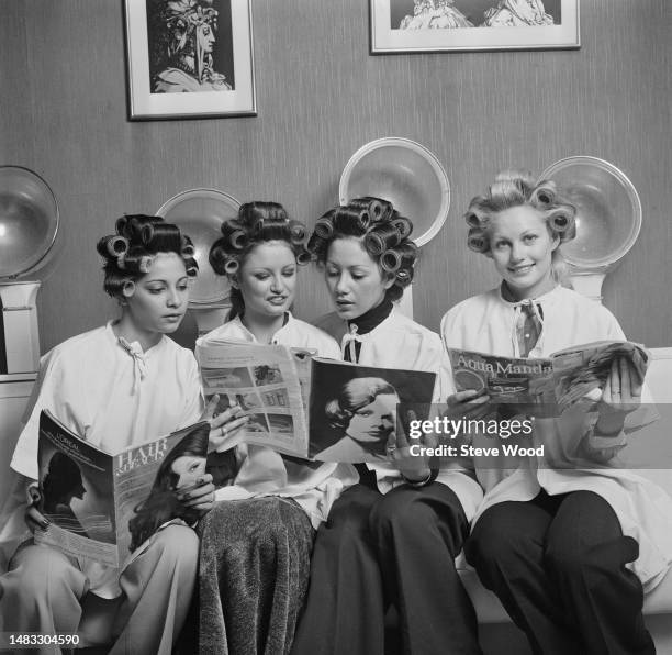 South African actress and model Anneline Kriel sits with her hair in curlers alongside three Miss World contestants at John, Mark and Paul's of...