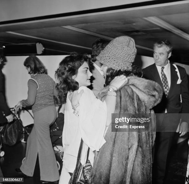 Liza Todd greets her mother, British-American actress Elizabeth Taylor, wearing a fur coat and a woollen hat, at Heathrow Aiport in London, England,...