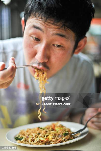 japanese man eating fried noodles - noodles eating stock pictures, royalty-free photos & images