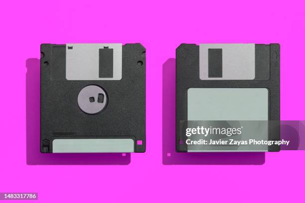 two floppy disks on magenta background - datenspeicher diskette stock-fotos und bilder