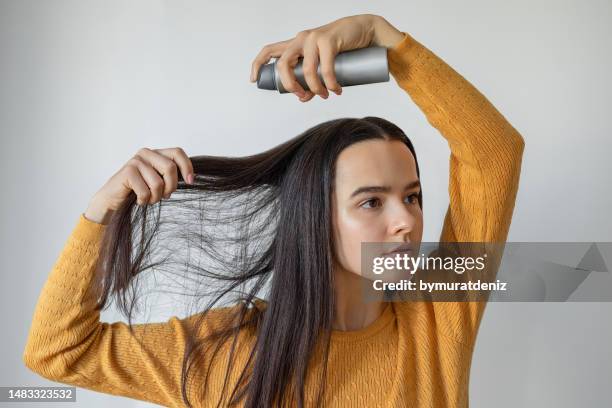 donna che applica spray per capelli - capelli sporchi foto e immagini stock
