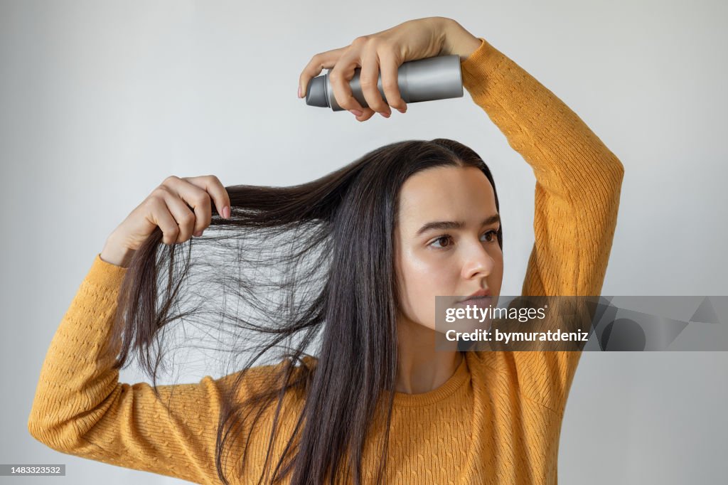 Woman applying hair spray