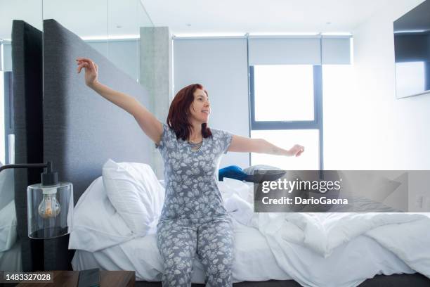 woman waking up in bed - woman 45 sleeping stock pictures, royalty-free photos & images