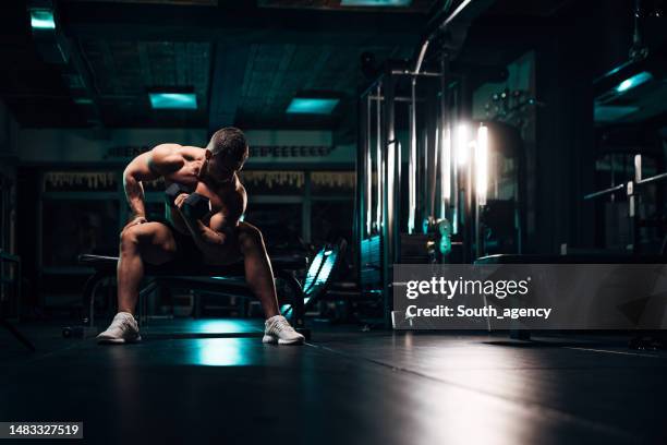 strong man exercising with dumbbell - weight bench stock pictures, royalty-free photos & images