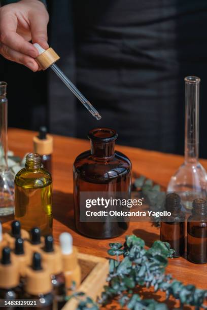 woman preparing aromatic liquid for diffuser. the process of creating perfume, workshop - flacon compte gouttes photos et images de collection