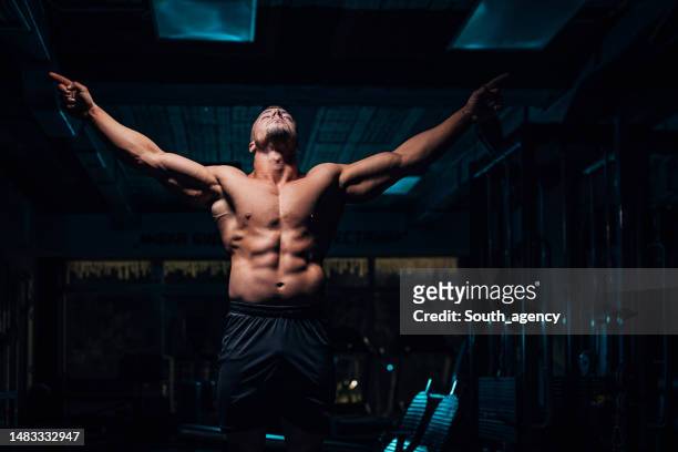 carrossier dans la salle de gym foncée - body muscles photos et images de collection