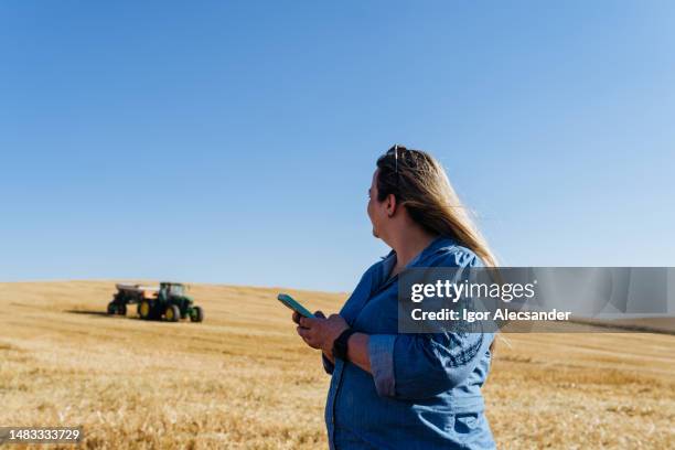 farmer woman using smartphone in the harvest - avena sativa stock pictures, royalty-free photos & images