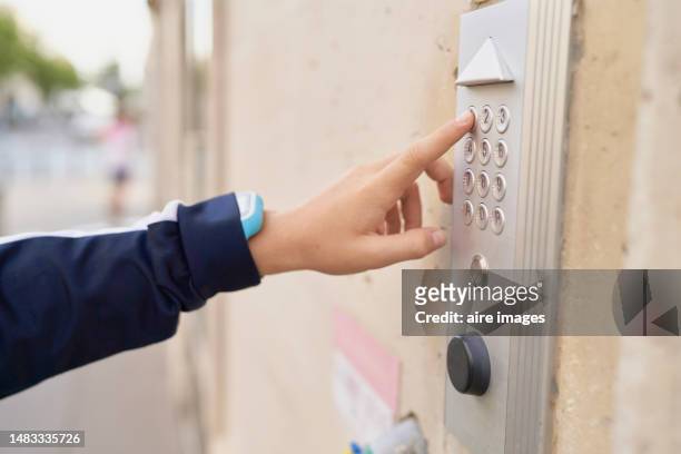 finger of boy or unidentifiable person outside ringing the doorbell of a house, side view - ringing doorbell photos et images de collection