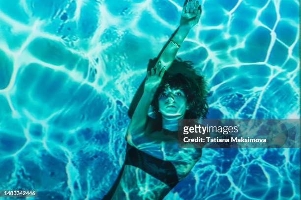 young woman under water, projection of water from a projector. - projector photos et images de collection