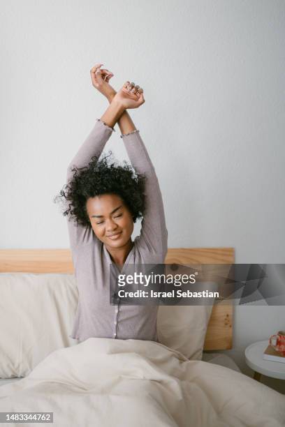 beautiful woman sitting on bed, smiling just woke up. - waking up stock pictures, royalty-free photos & images
