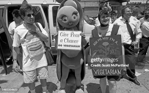 View of three pro-vegetarian activists at the annual Nathan's Hot Dog Eating Contest at Coney Island, New York, New York, July 4, 1997. From left, a...