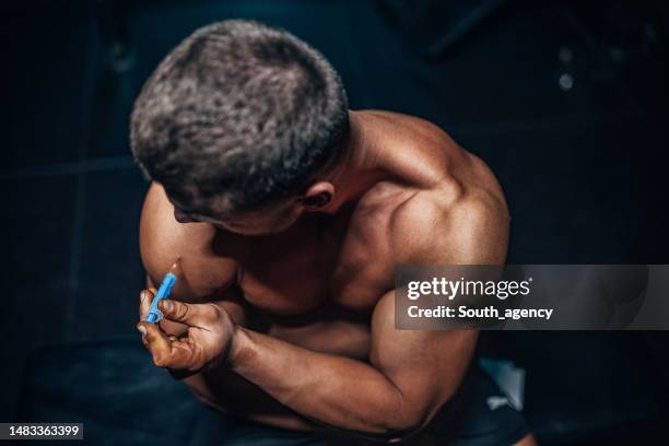 hombre inyectándose esteroides - doping fotografías e imágenes de stock