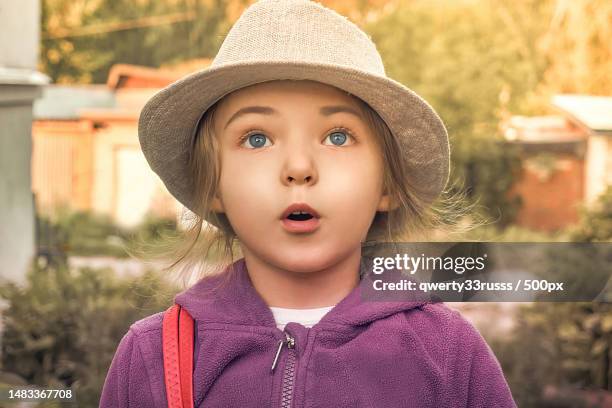 a girl in a fleece jacket and hat,looks surprised summer sunny day for walking and traveling - blue white summer hat background stock pictures, royalty-free photos & images