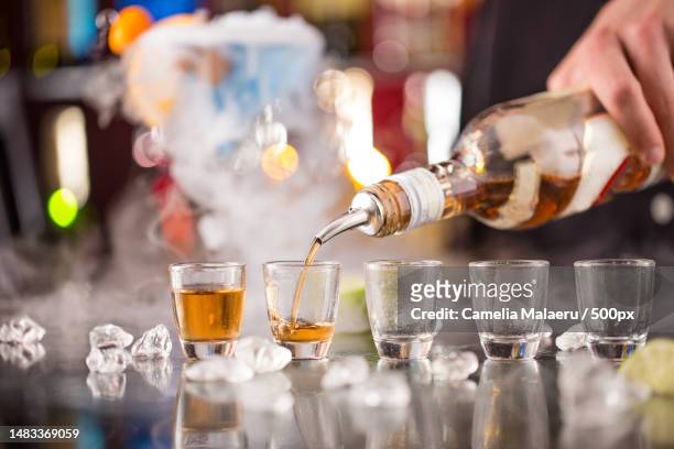 cropped hand pouring drink in glass,romania - rubbing alcohol stock pictures, royalty-free photos & images