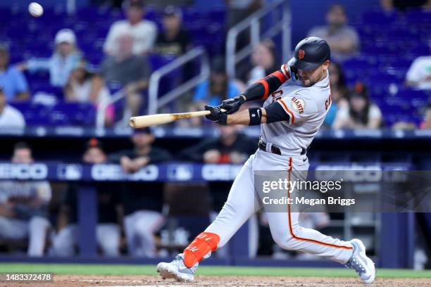 Michael Conforto of the San Francisco Giants hits a home run against the Miami Marlins during the 11th inning at loanDepot park on April 19, 2023 in...