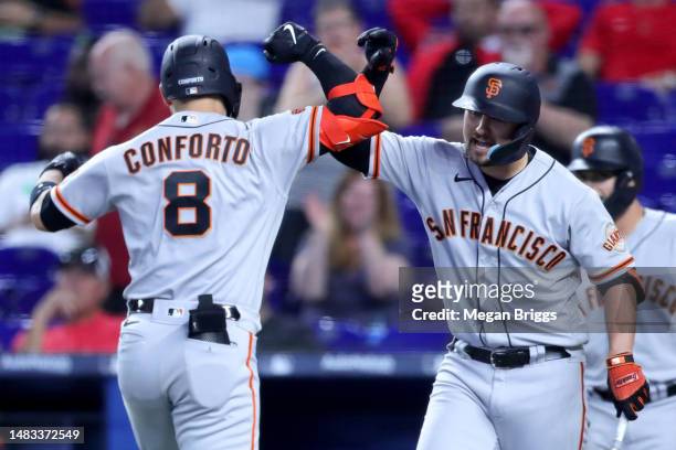 Michael Conforto of the San Francisco Giants celebrates with teammate J.D. Davis after hitting a home run against the Miami Marlins during the...