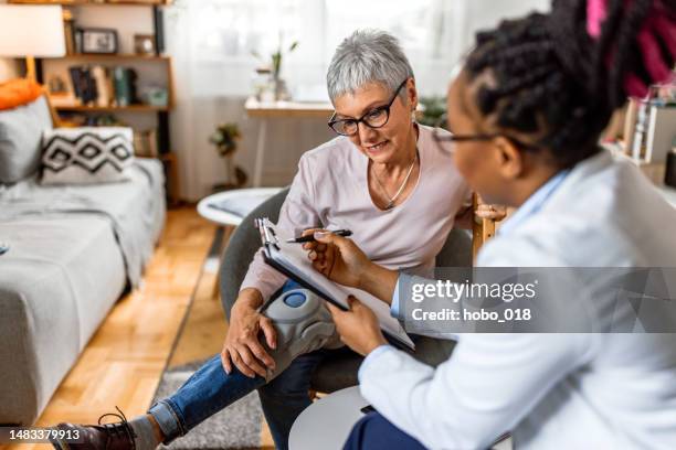 senior woman recovering from injury at home - house call stockfoto's en -beelden