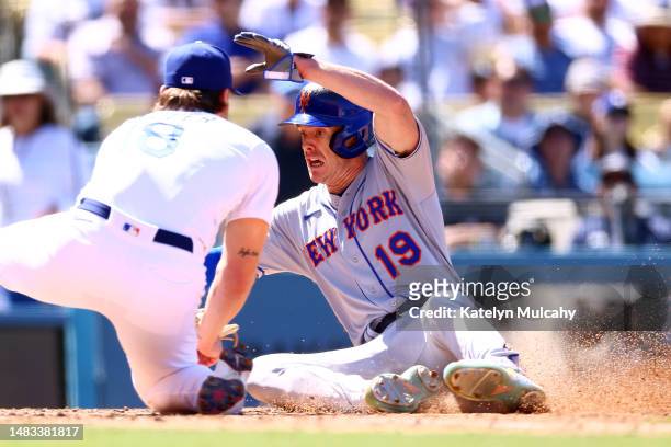 Mark Canha of the New York Mets slides into home plate against Shelby Miller of the Los Angeles Dodgers during the ninth inning at Dodger Stadium on...