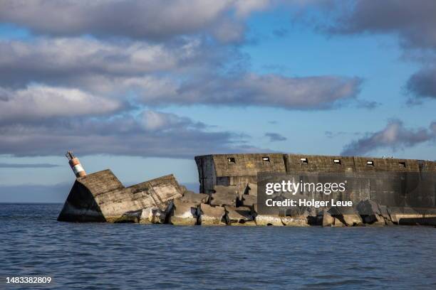 hurricane-damaged jetty at harbor entrance - flores stock pictures, royalty-free photos & images