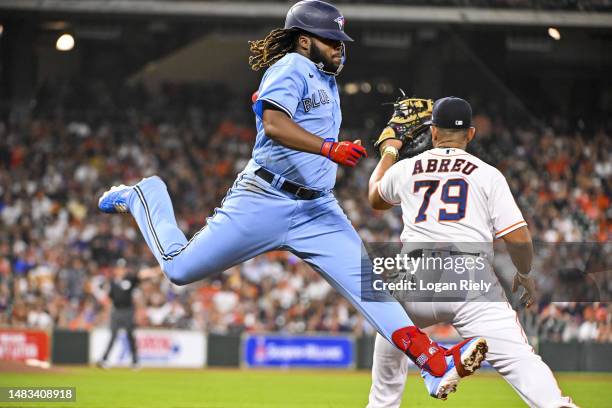 Vladimir Guerrero Jr. #27 of the Toronto Blue Jays reaches for first base in the fourth inning against José Abreu of the Houston Astros at Minute...