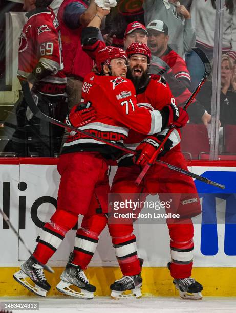 Jesper Fast of the Carolina Hurricanes celebrates with Brent Burns after scoring the game-winning goal in overtime against the New York Islanders in...