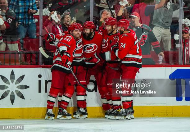 Jesper Fast of the Carolina Hurricanes celebrates with teammates after scoring the game-winning goal in overtime against the New York Islanders in...