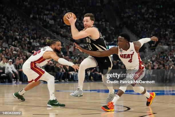 Pat Connaughton of the Milwaukee Bucks drives against Caleb Martin and Victor Oladipo of the Miami Heat during the first half of Game Two of the...