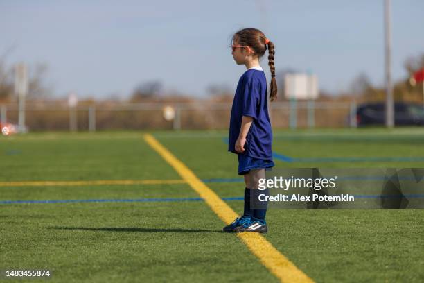 konzentriertes, 7-jähriges mädchen, das sich darauf vorbereitet, fußball zu spielen. - 6 7 years stock-fotos und bilder