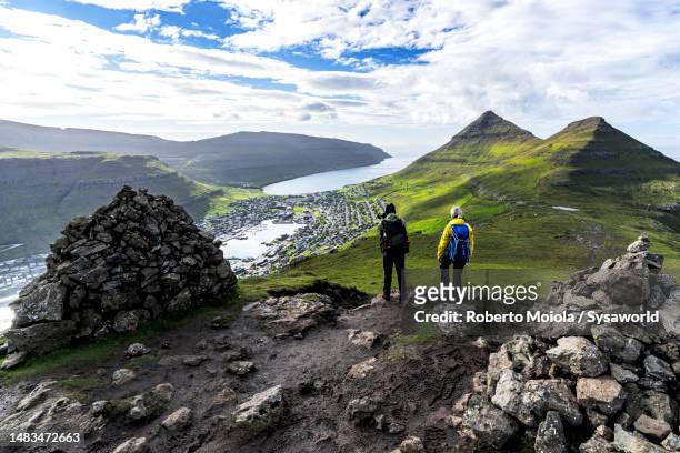 tourists looking at klaksvik from mountains, faroe islands - faroe islands stock pictures, royalty-free photos & images