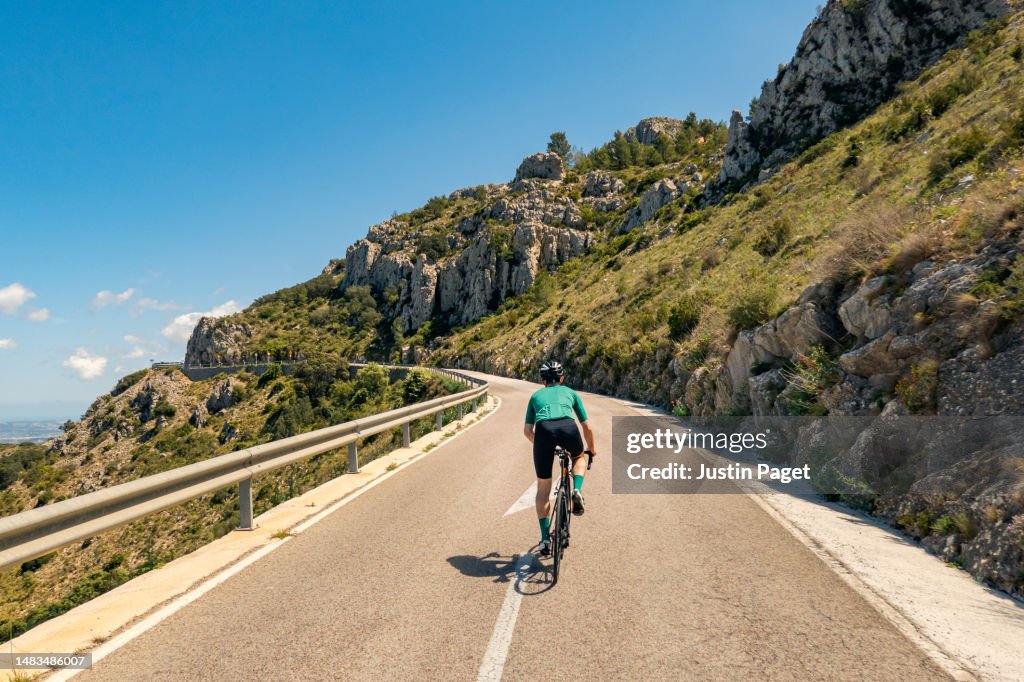 Rear view of a cyclist climbing in the Spanish mountains