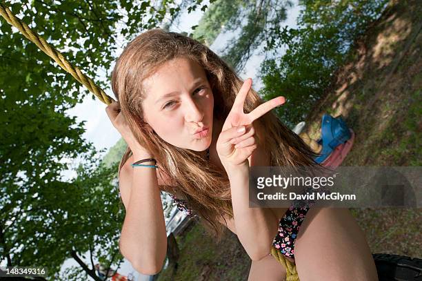 girl  on a rope swing flashing a peace sign - 12 13 years ストックフォトと画像