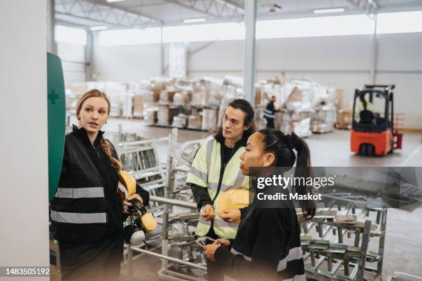 female worker explaining first aid kit to colleagues at warehouse - safety kit imagens e fotografias de stock