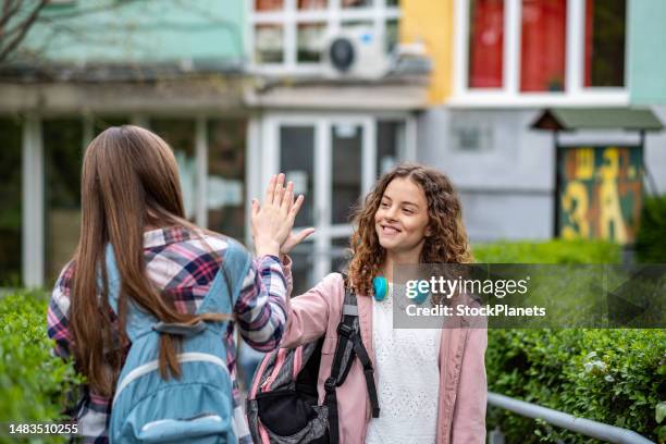 the girls greet each other in the school yard - teenagers greeting stock pictures, royalty-free photos & images