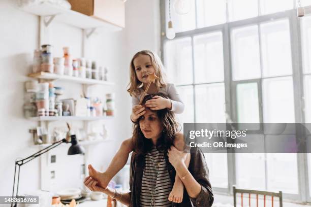 mother carrying daughter with magic wand on shoulders - magic wand stock pictures, royalty-free photos & images