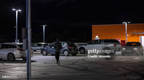 man walking in parking space - parking stock pictures, royalty-free photos & images