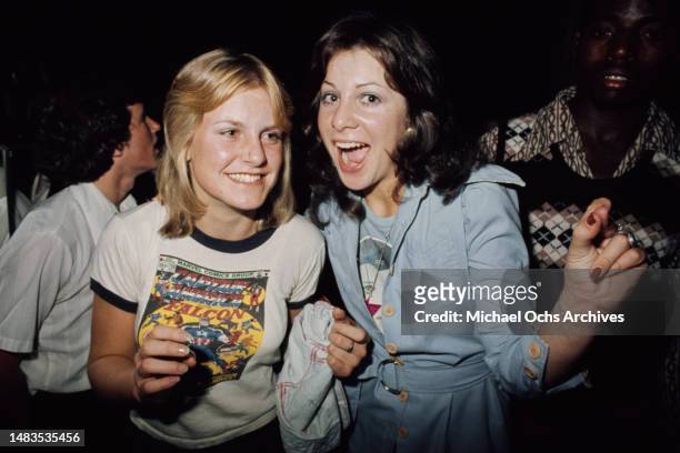 Two young women, the blonde woman wearing a 'Captain America' t-shirt and the brunette woman wearing a pale blue outfit, at Rodney Bingenheimer's...