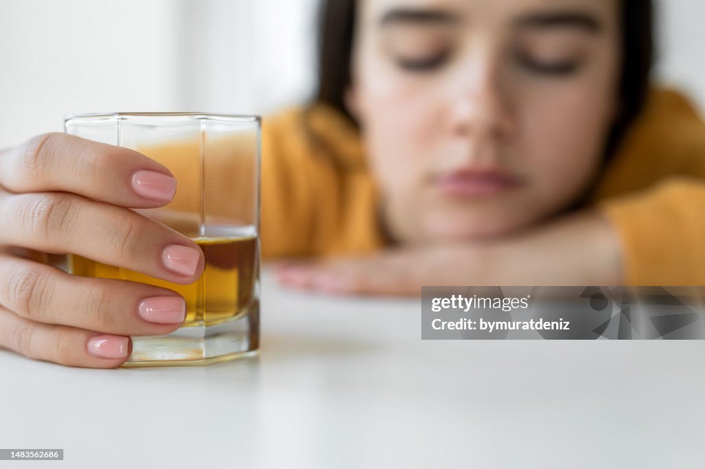 Femme alcoolique contrariée assise avec du whisky seul