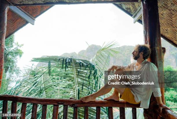 man sitting on the balcony and looking at jungles - thailand hotel stock pictures, royalty-free photos & images