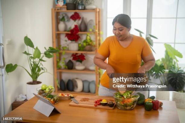 plus size , caucasian woman learning to make salad and healthy food from social media - eating fiber stock pictures, royalty-free photos & images