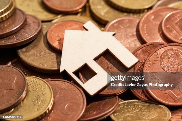 wooden house on a pile of coins of the european union - european union coin stock pictures, royalty-free photos & images