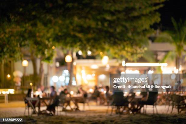 blurred of people chill out at night party on beach. - beach party backgrounds stock pictures, royalty-free photos & images