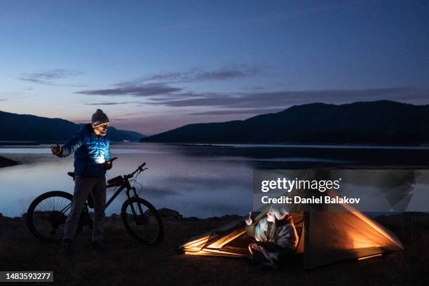 menschen in der natur. camping zu zweit am seeufer. - fahrrad nacht stock-fotos und bilder