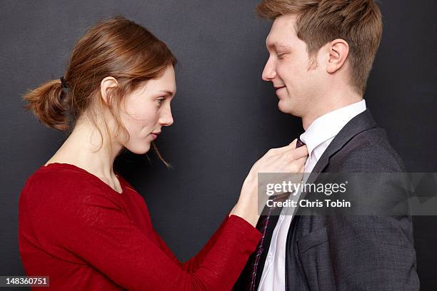 woman adjusting her husband's tie - adjusting necktie stockfoto's en -beelden