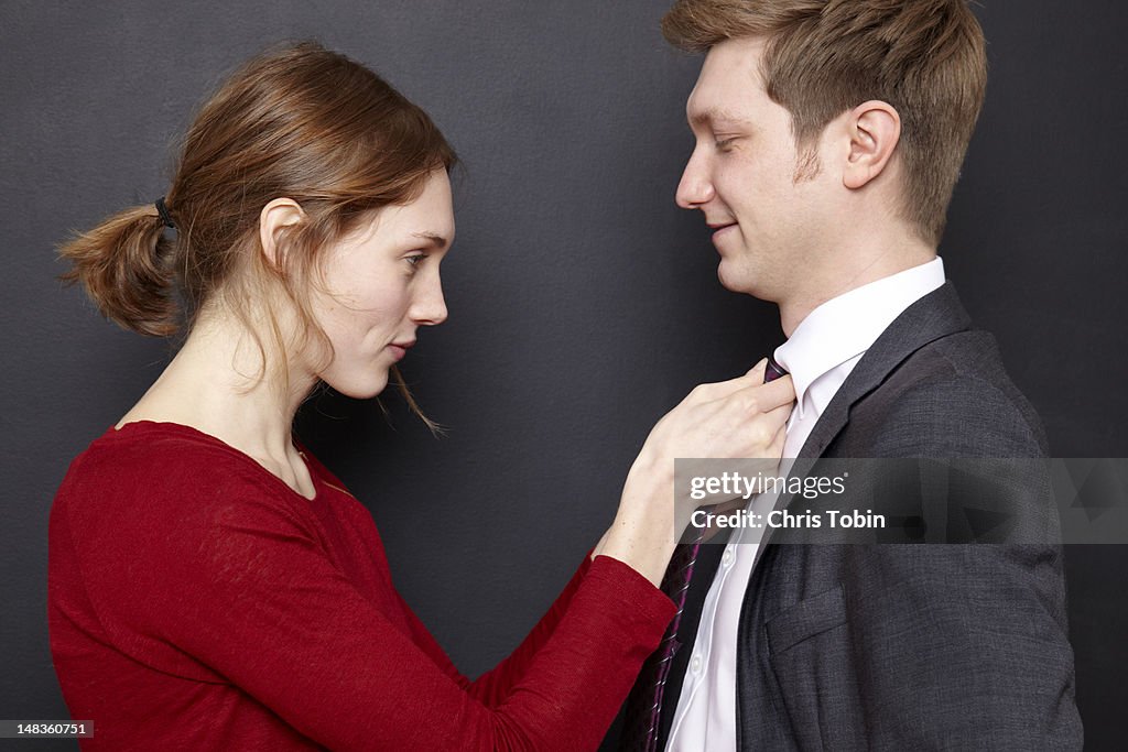 Woman adjusting her husband's tie