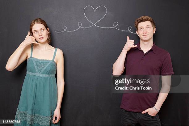 young couple calling each other - belt stockfoto's en -beelden