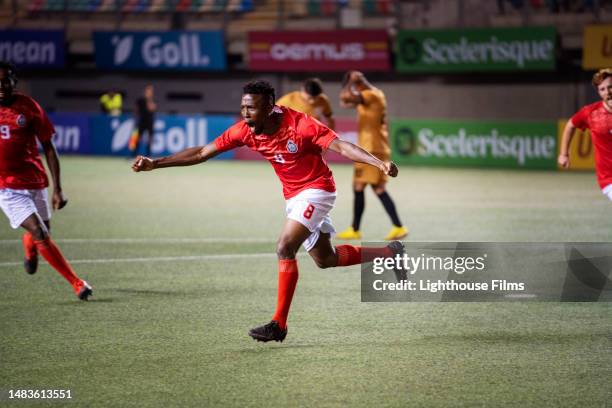 ecstatic team of soccer players run and enthuastically shout after winning an international match - midfielder soccer player stockfoto's en -beelden