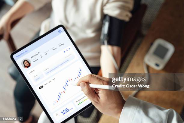 elevated view of doctor explaining  health report with patient during medical consultation - healthcare technology stock pictures, royalty-free photos & images