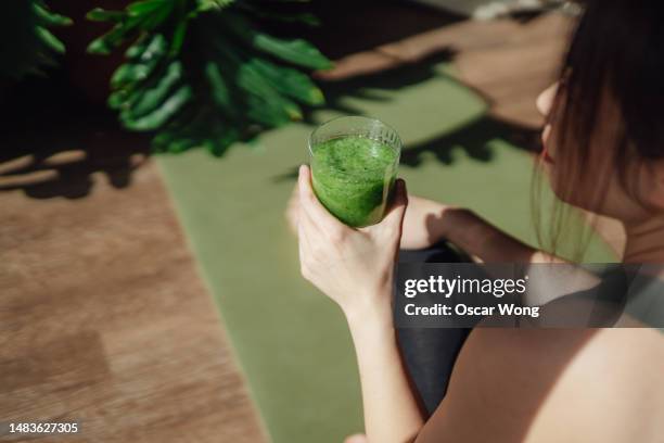 a good morning routine with drinking green juice and practising yoga - stoffwechsel entgiftung stock-fotos und bilder
