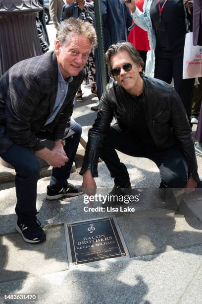 Michael Bacon and Kevin Bacon pose by their plaque at the 2023 Philadelphia Music Alliance Walk Of Fame Plaque Unveilings outside of University of...